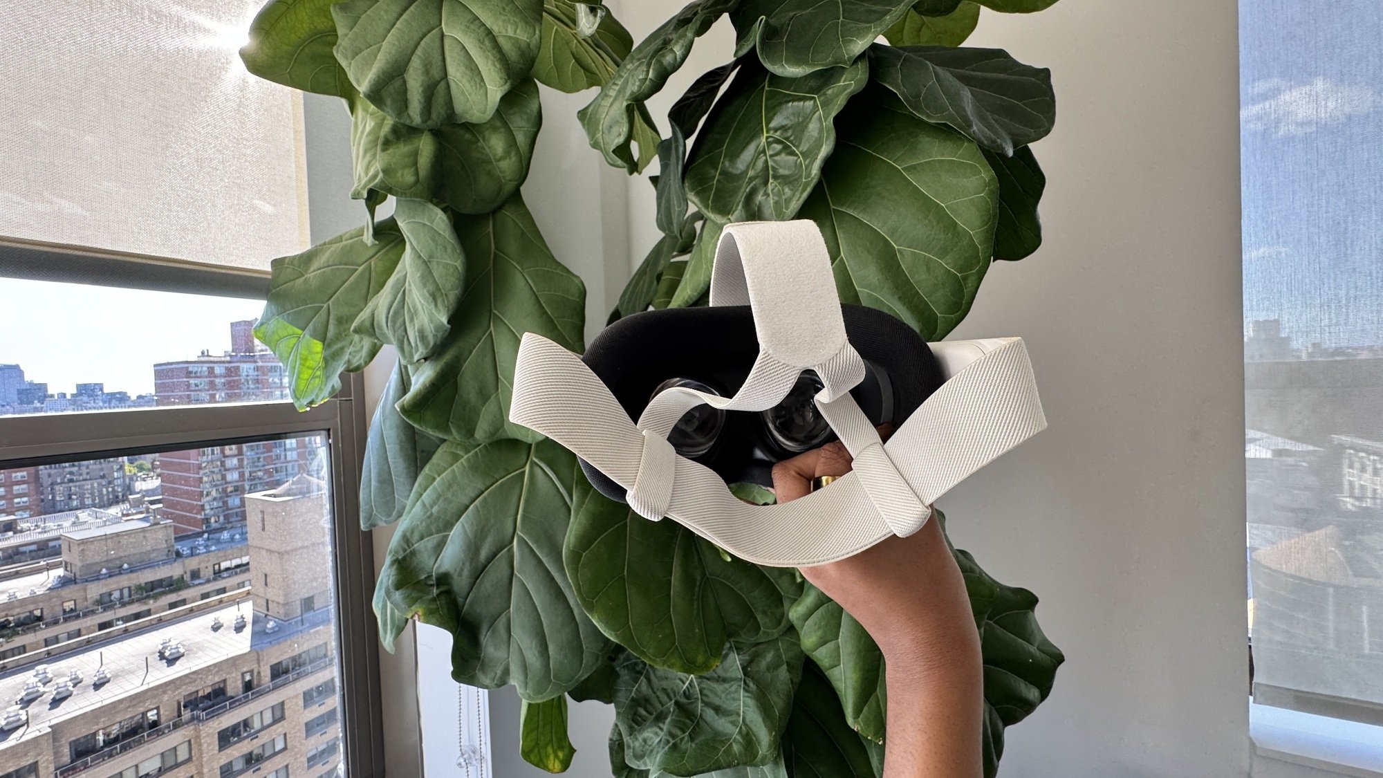 Woman holding the Quest 3S in front of a plant