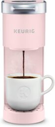 a pink keurig coffee maker with white mug of coffee