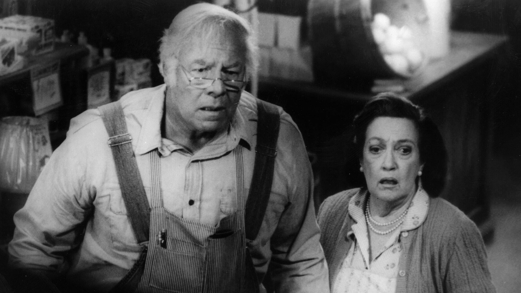 A man and a woman looked shocked in a black and white film still.