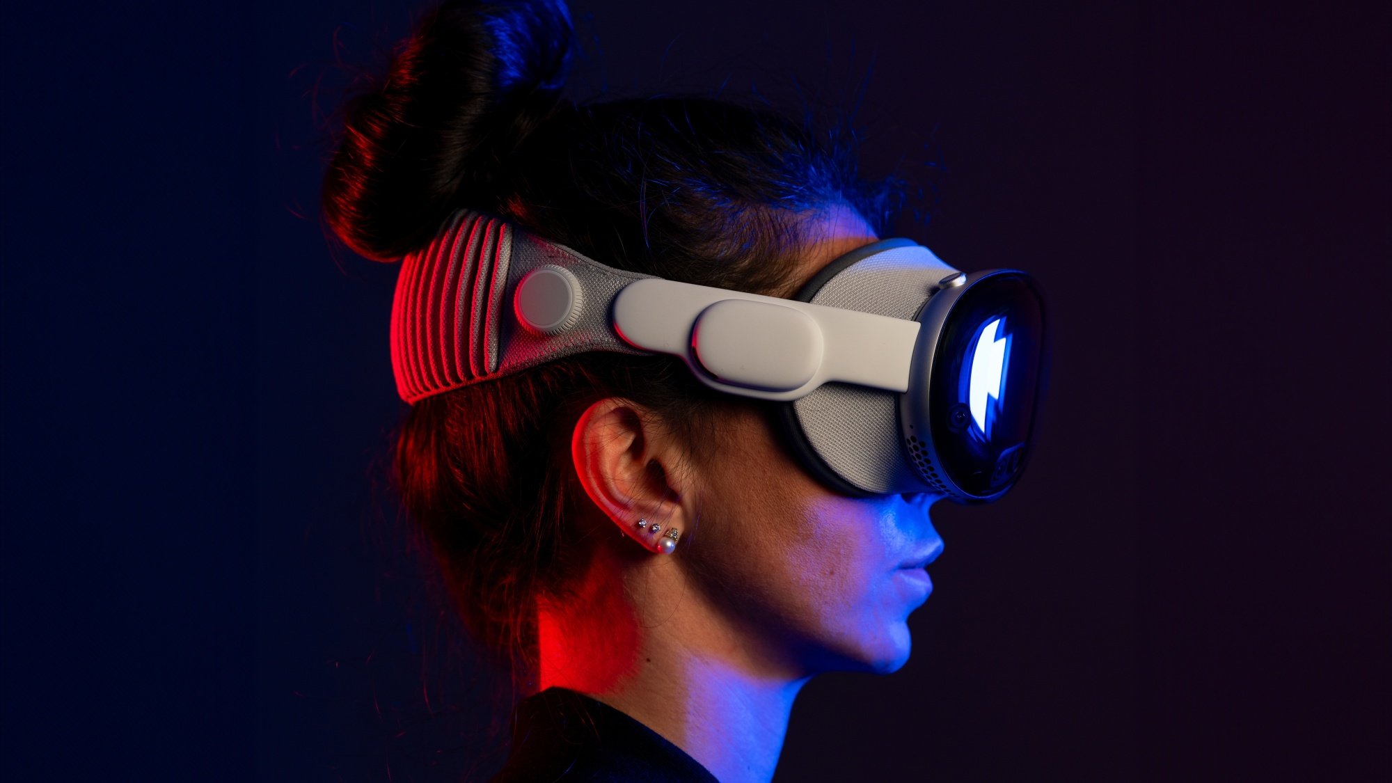 Woman wearing Apple Vision Pro in dark background