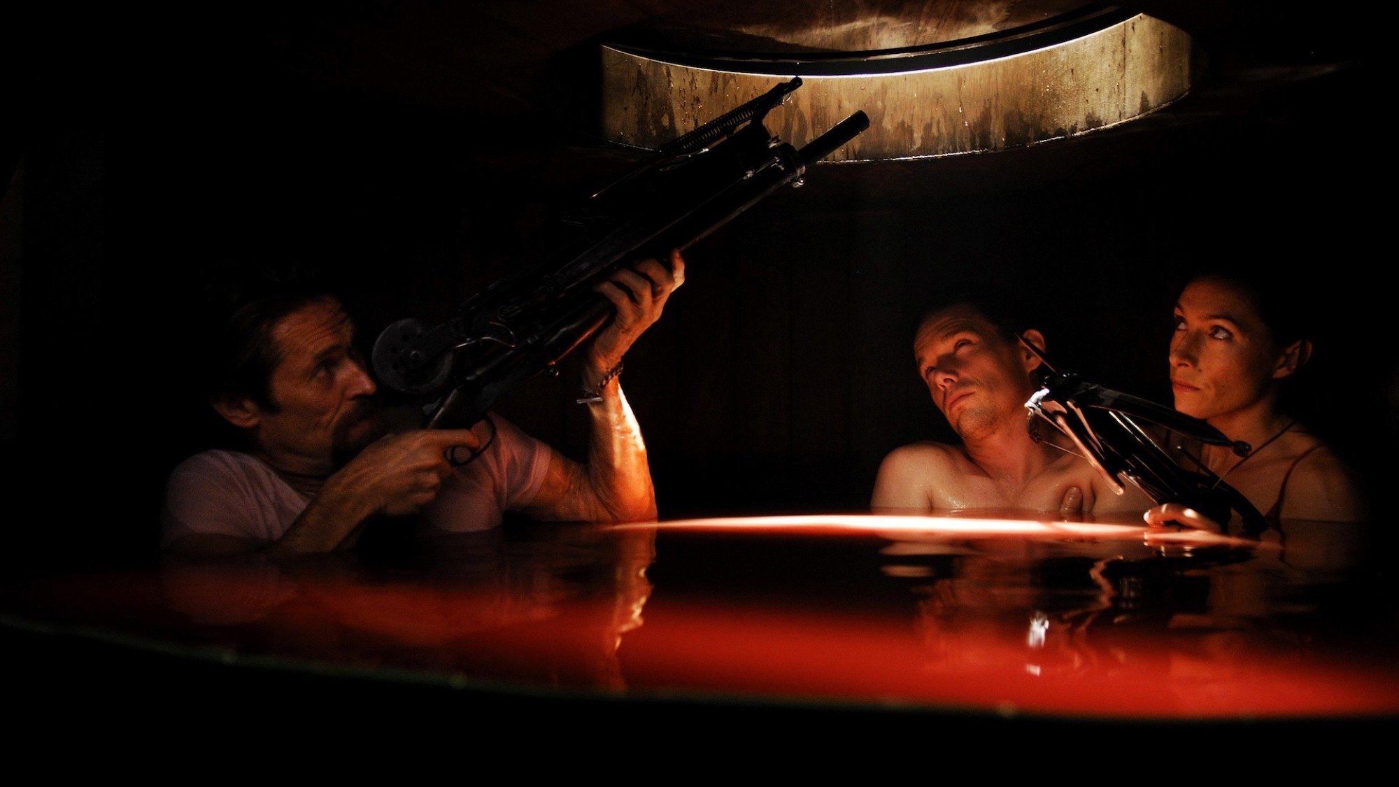 Willem Dafoe, Ethan Hawke, and Claudia Karvan are in a dark red room in the film "Daybreakers".