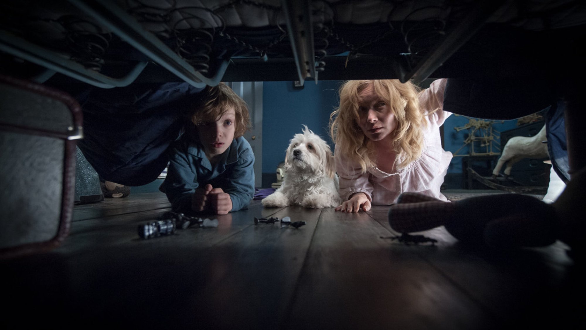 Noah Wiseman and Essie Davis look under a bed in "The Babadook."