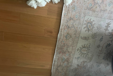 Hardwood floor and rug with blanket in peripheral