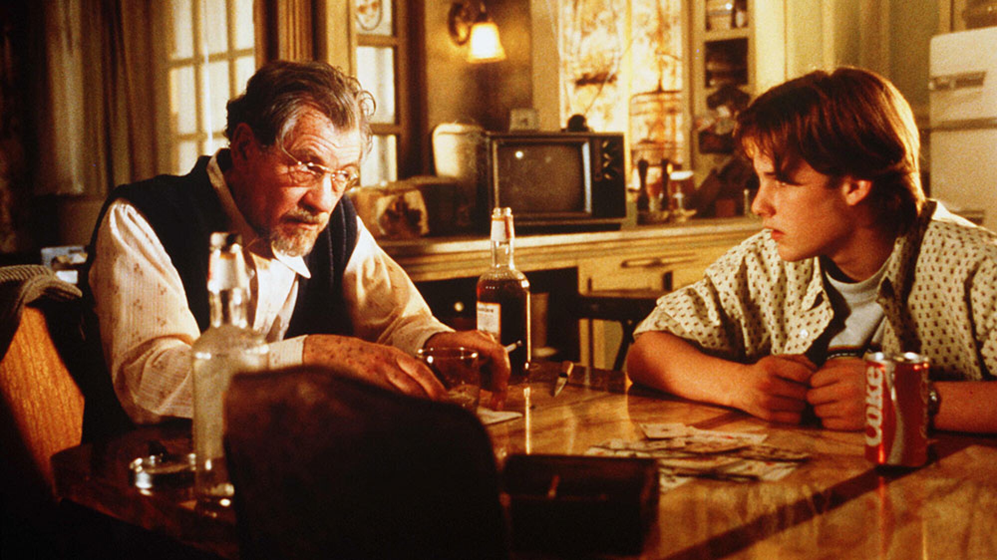 Two men sit together at a dining table.