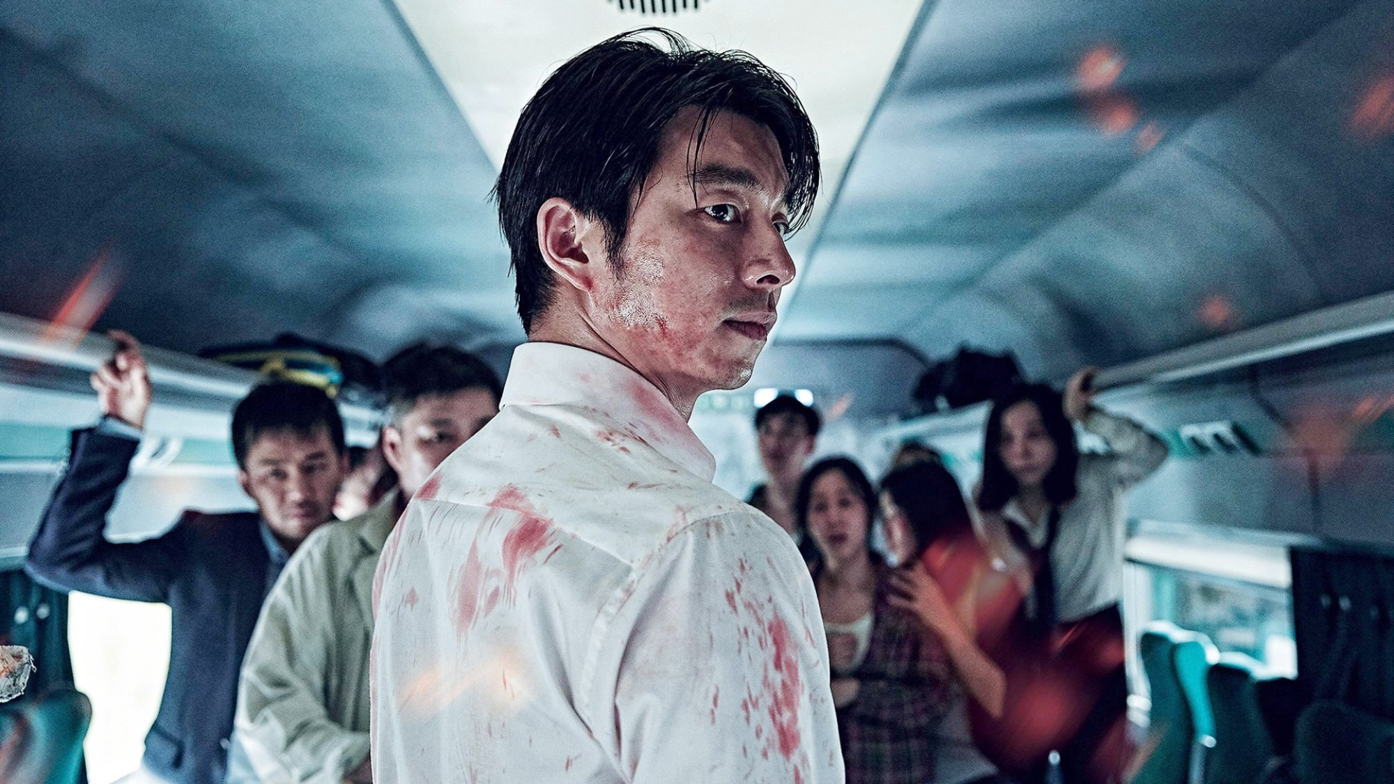 Actor Gong Yoo stands in a train carriage with a bloodied shirt in the film "Train to Busan."