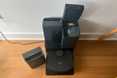 Eufy X10 Pro Omni robot vacuum and dock with lid open and water tank sitting beside it