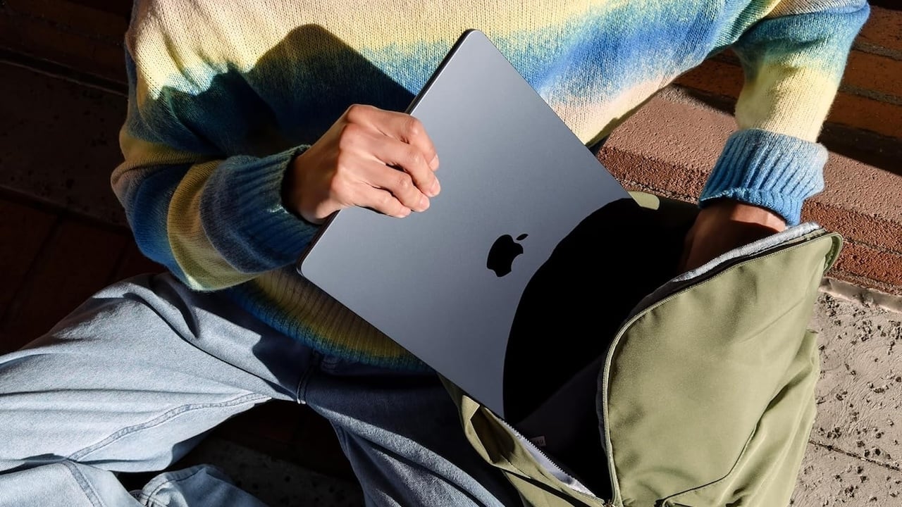 Person putting MacBook into a backpack