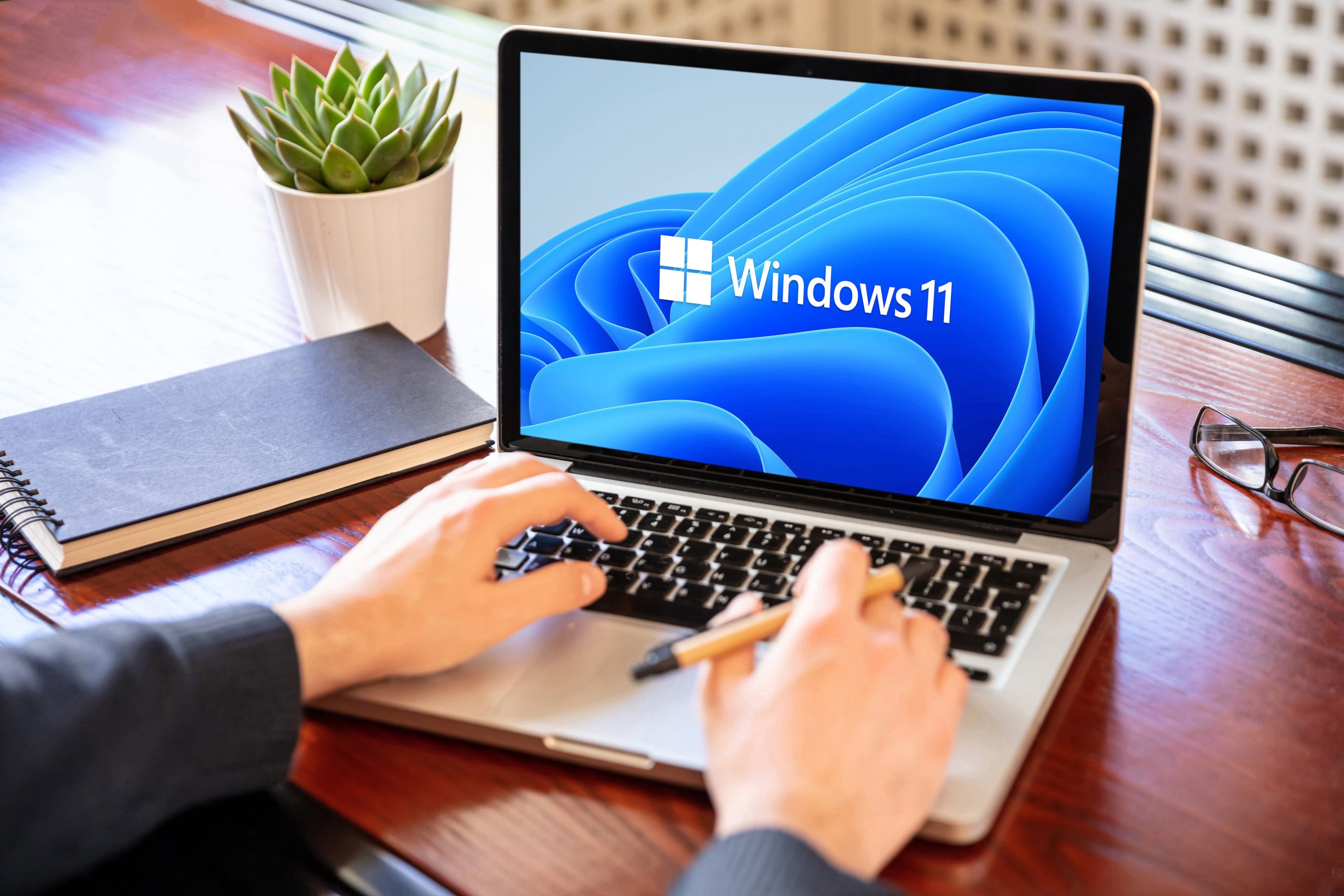 Man working with a laptop, Windows 11 new Microsoft operating system on computer screen