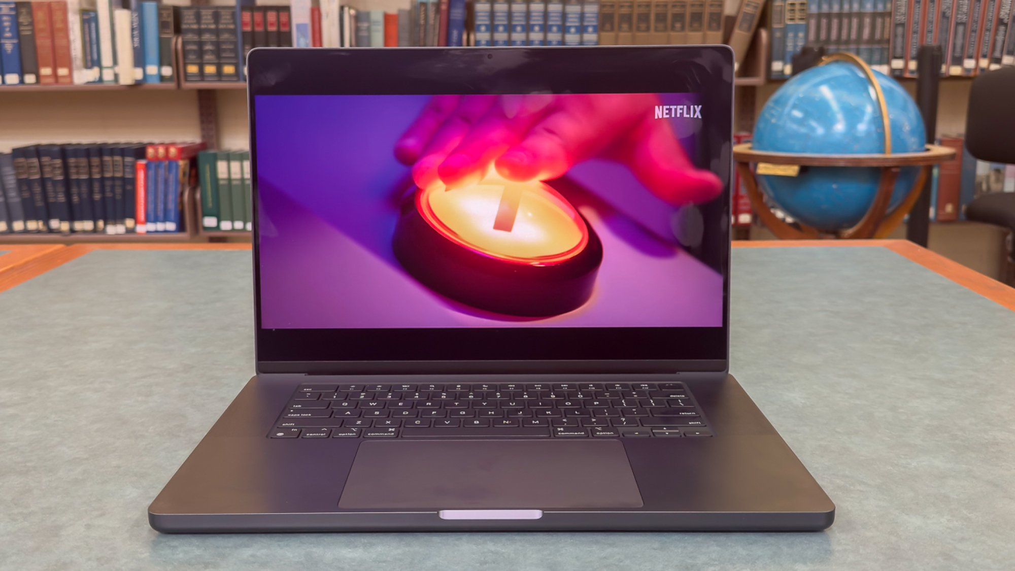 Apple MacBook Pro 16-inch on a table with books in the background